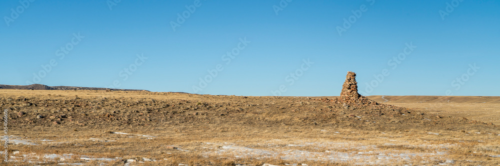large stone cairn overlooking Colorado prairie, Soapstone Prairie Natural Area near Fort Collins in winter scenery, panoramic banner large stone cairn overlooking Colorado prairie, Soapstone Prairie Natural Area near Fort Collins in winter scenery, panoramic banner
