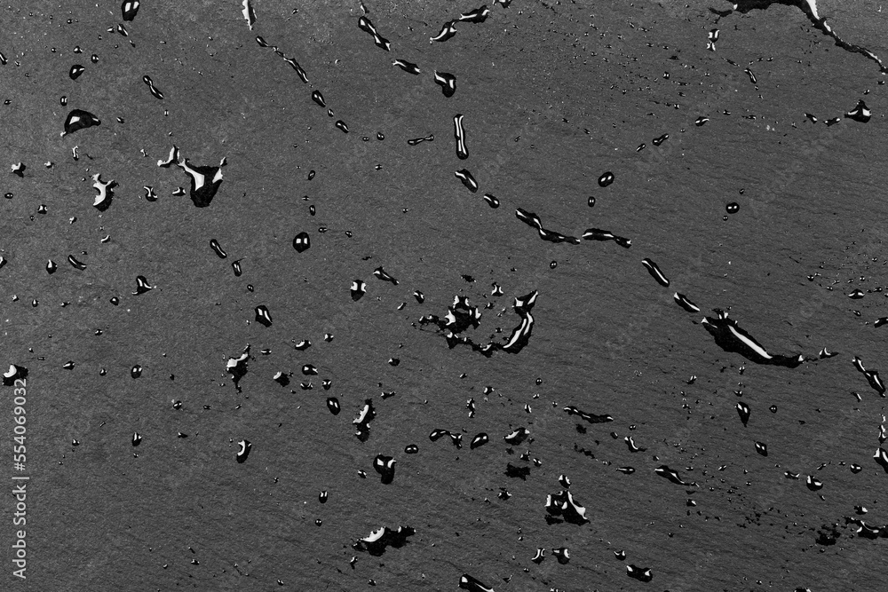 Water on dark flat stone surface Water on dark flat stone surface