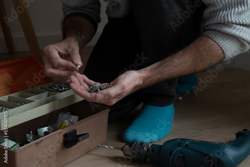 person hands of human holding screws and a toolbox 