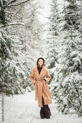 Portrait of a young beautiful girl in the winter forest.