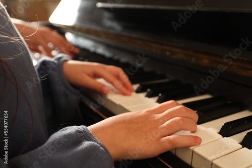 Little child playing piano, closeup. Music lesson