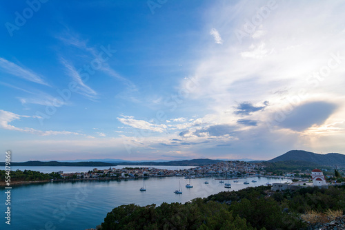 Beautiful view of Ermioni sea lagoon with moored yachts and boats at sunset time.