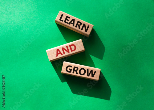 Learn and grow symbol. Concept words 'Learn and grow' on wooden blocks. Beautiful green background. Business and Learn and grow concept. Copy space.