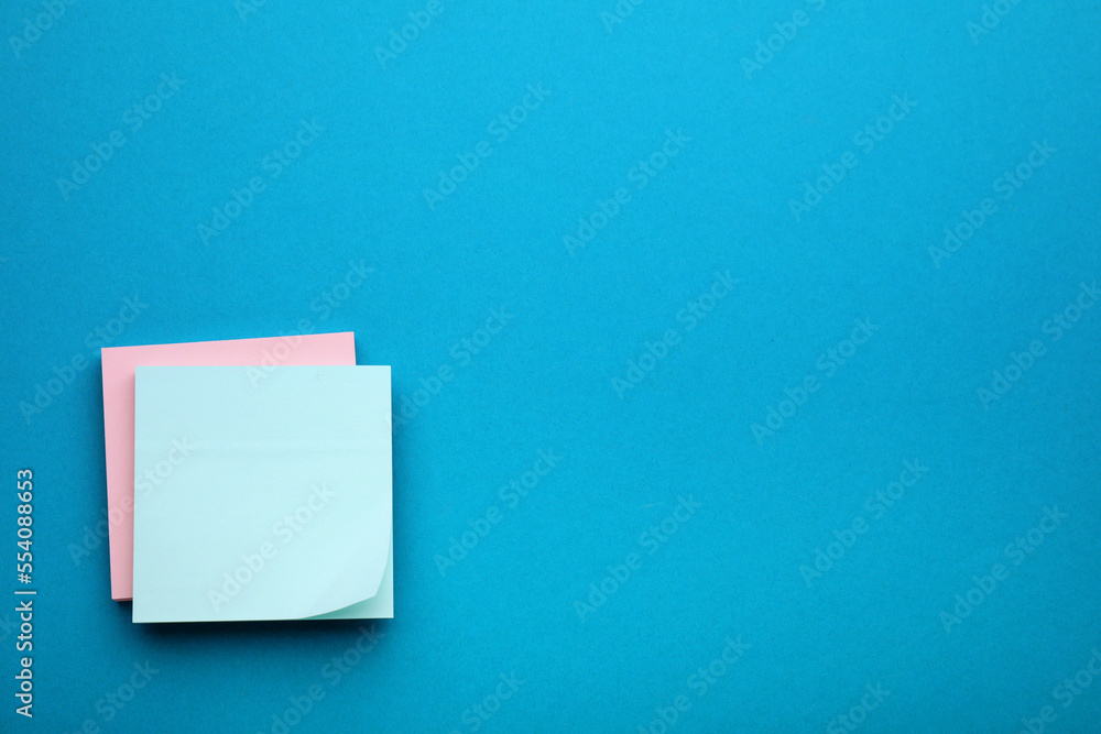 Paper notes on blue background, top view Paper notes on blue background, top view