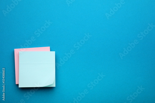 Paper notes on blue background, top view