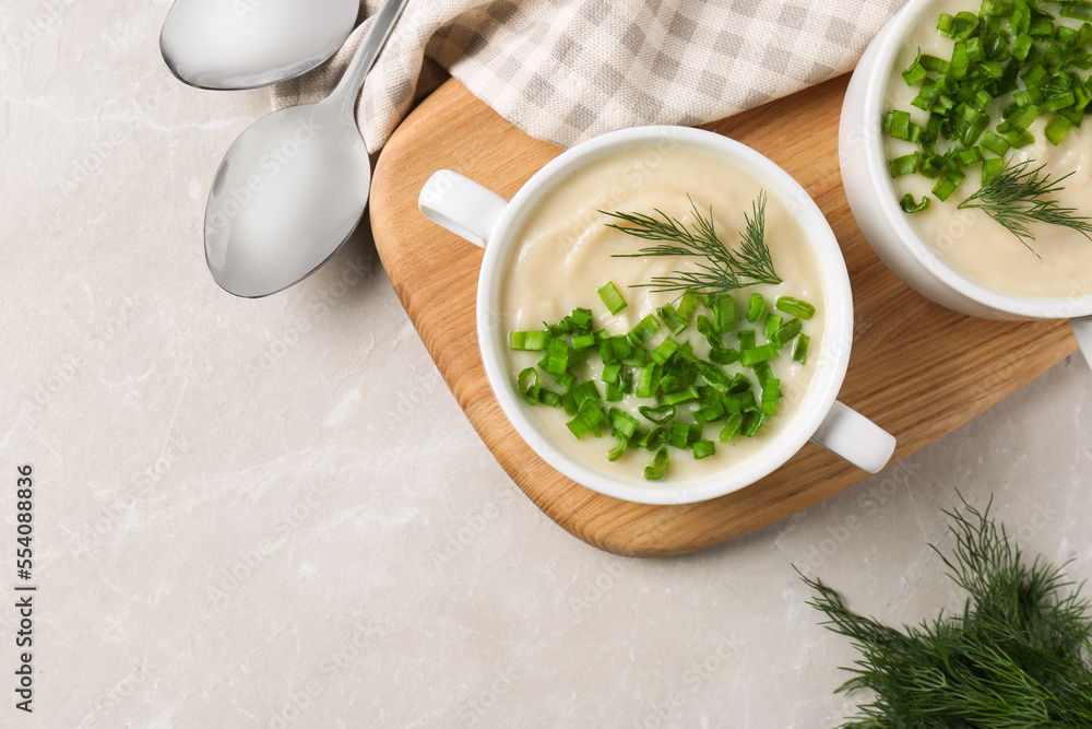 Bowls with tasty creamy soup of parsnip served on light grey table, flat lay. Space for text Bowls with tasty creamy soup of parsnip served on light grey table, flat lay. Space for text