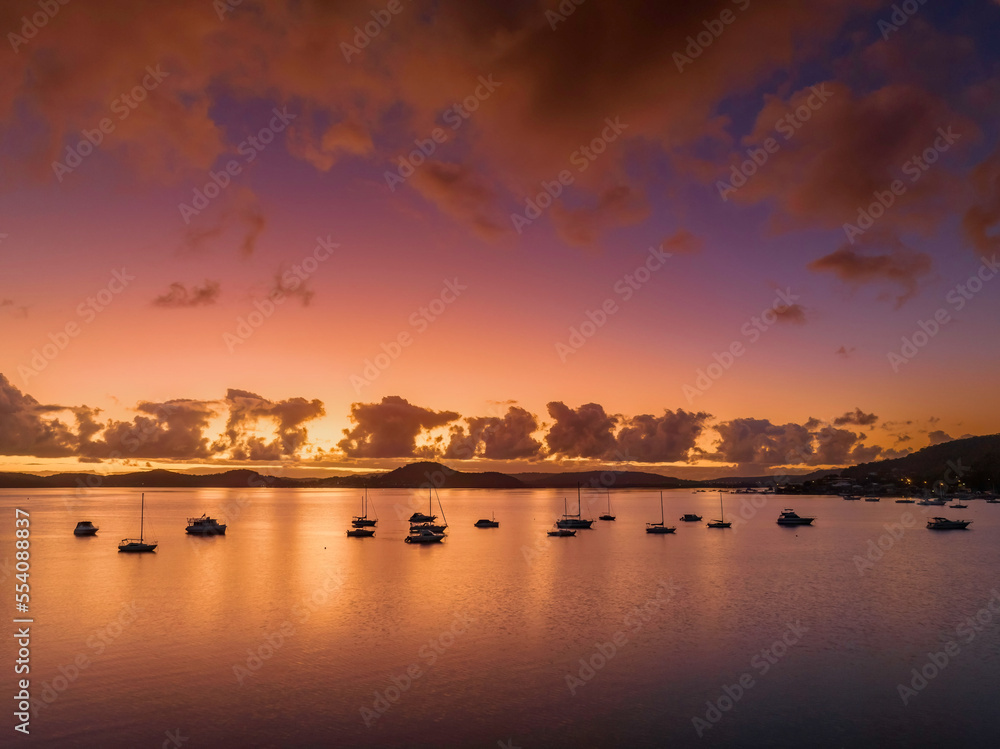 Aerial sunrise waterscape with boats, clouds and reflections