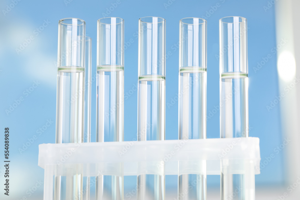 Liquid in test tubes on blurred background, closeup Liquid in test tubes on blurred background, closeup