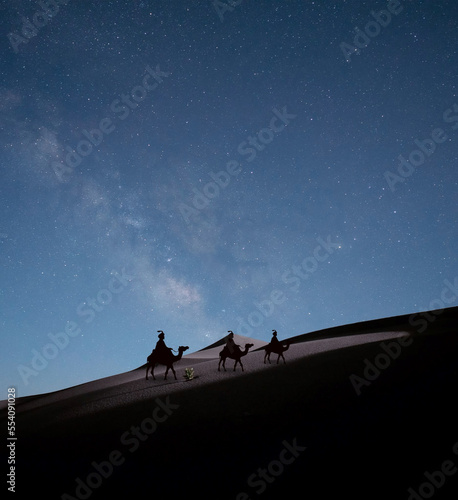 Los reyes magos del Oriente  en sus camellos  en el desierto  guiados por la estrella polar. 