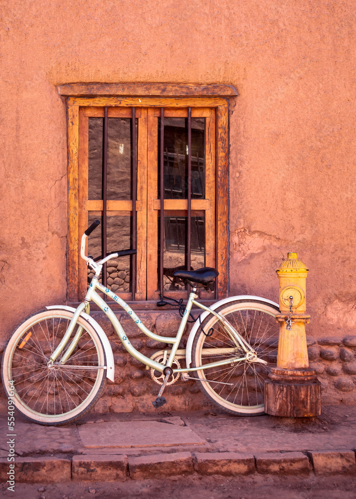 White bicycle, window and yellow fure hydrant on a street San Pedro Atacama, Chile