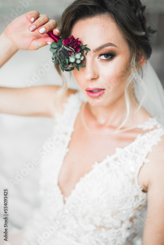 Gorgeous bride in robe posing and preparing for the wedding ceremony face in a room