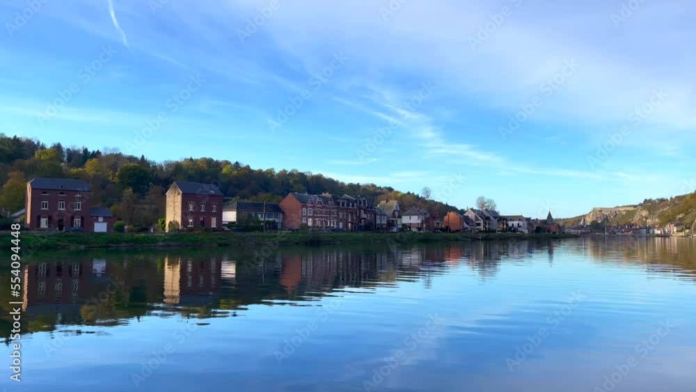 View of old buildings with the reflection on the Meuse river in Dinant, Belgium View of old buildings with the reflection on the Meuse river in Dinant, Belgium