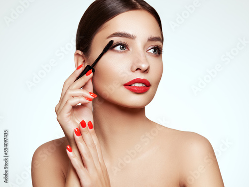 Obraz na płótnie Beauty woman applying black mascara on eyelashes with makeup brush