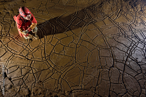 A speleologist admires cracked mud formations on the floor of a passage in the lower section of Gai Dong. photo