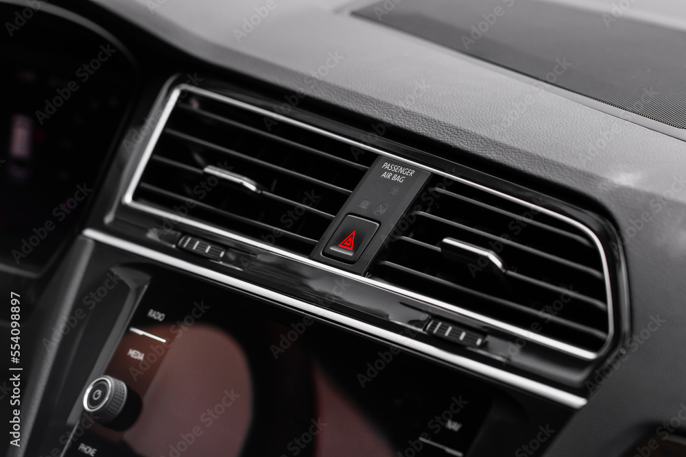 Red triangle hazard light button on car dashboard. Car media buttons dashboard. Detail of a modern car controllers. Red triangle hazard light button on car dashboard. Car media buttons dashboard. Detail of a modern car controllers.
