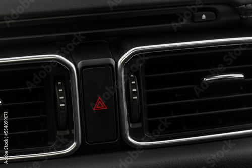 Red triangle hazard light button on car dashboard. Car media buttons dashboard. Detail of a modern car controllers. © Roman