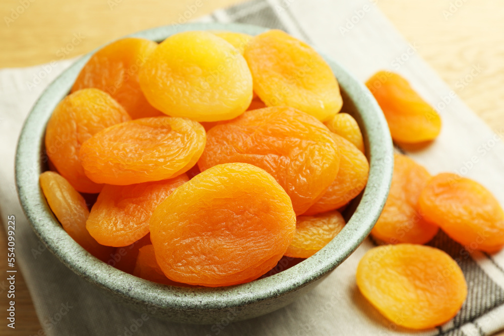 Bowl of tasty apricots on wooden table, closeup. Dried fruits Bowl of tasty apricots on wooden table, closeup. Dried fruits