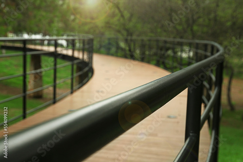 Beautiful pathway handrails in park near trees