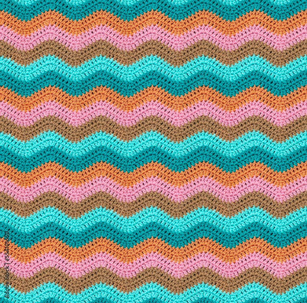Seamless knitted pattern in the form of zigzags is crocheted with threads of muted tones. Acrylic baby yarn. African style.