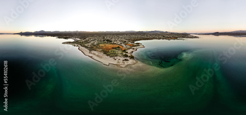 wide angle view from aerial view drone shot of lake mohave in the national recreation area of lake mead in nevada and arizona with the sun setting showing six mile cove and its sand
