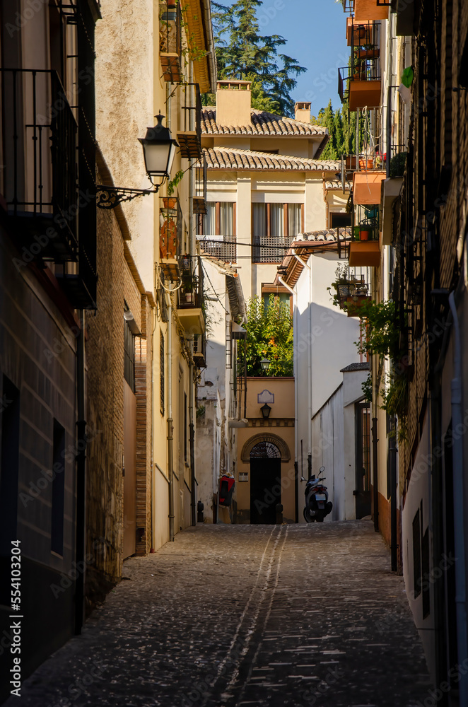 Narrow street with old buildings in Granada (Spain)