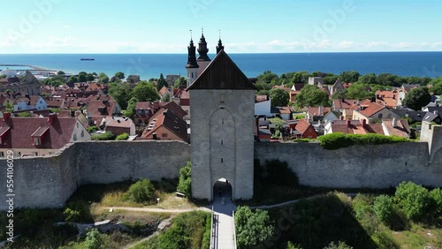 Aerial drone footage flying over the town on the Swedish island Gotland, Visby located in the Baltic Sea. Fortified wall in the Gotland island. Ancient medieval city walls, medieval Sweden city.  photo