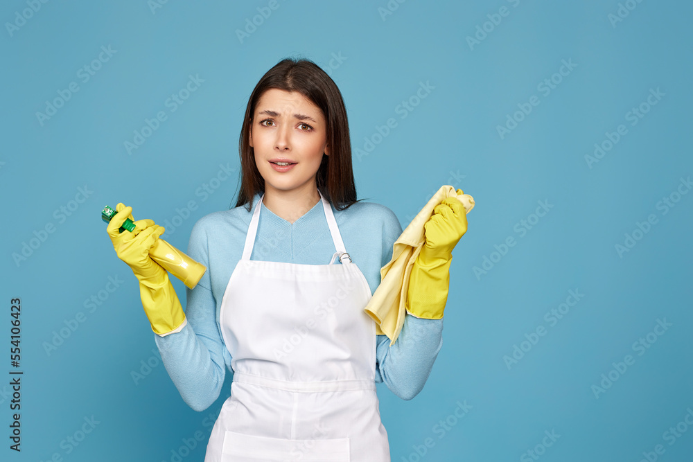 frowning woman cleaner apron with cleaning rag and detergent sprayer frowning woman cleaner apron with cleaning rag and detergent sprayer