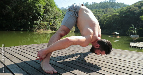 Fit Man training Yoga outdoors. Person lifting body with upper body photo