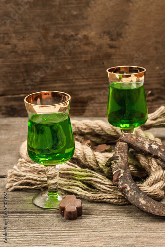 St. Patrick's Day concept. Traditional green cocktail, sweet chocolate in the shape of clover leaves photo