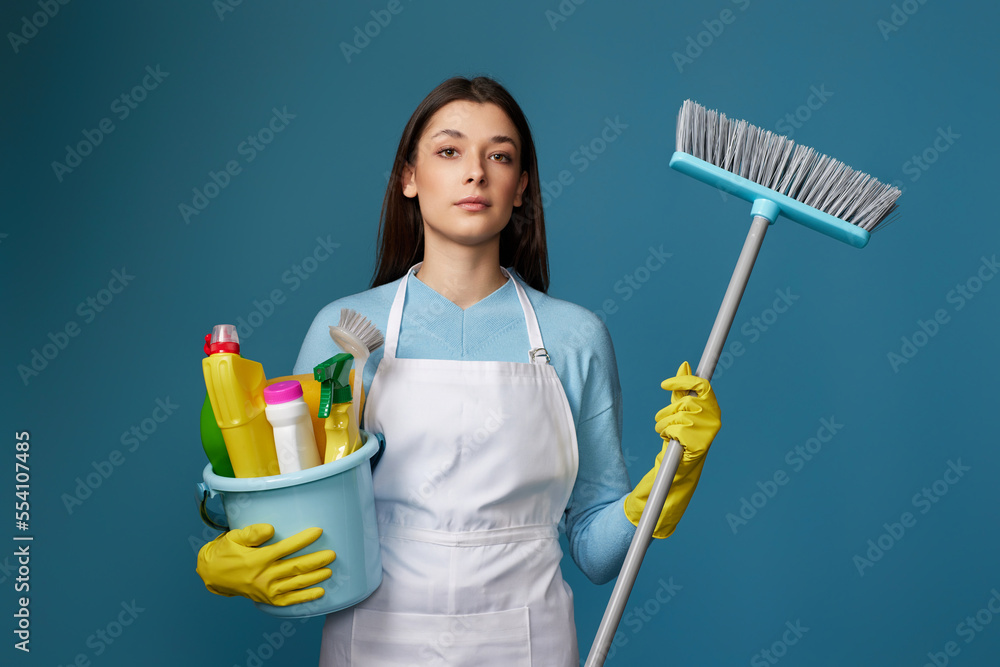 woman in cleaner apron holding bucket of detergents and broom woman in cleaner apron holding bucket of detergents and broom