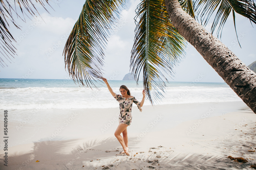 Beautiful girl near the palm tree on the tropical beach Beautiful girl near the palm tree on the tropical beach
