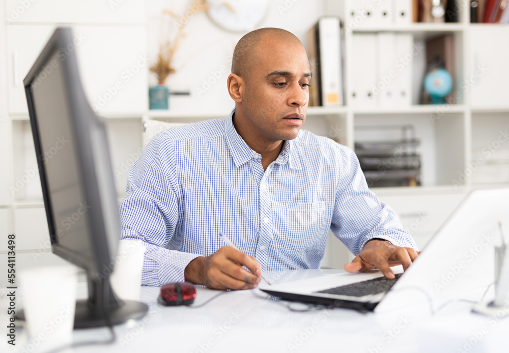Fototapeta premium Successful businessman working with papers and laptop in office
