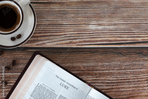 Konstfotografi Open holy bible book Luke gospel with coffee cup on wooden background