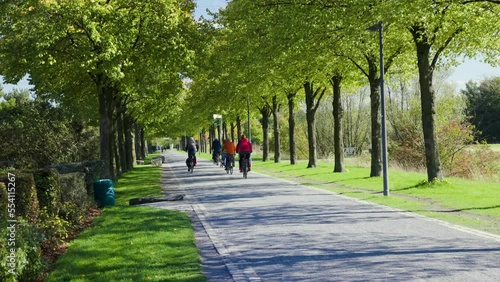 Cyclists ride along the path in sunny weather in the Nordsternpark in Gelsenkirchen near Essen, Germany.