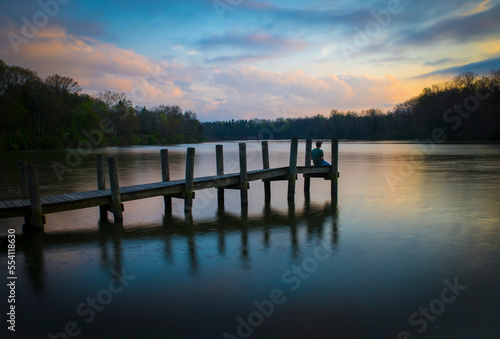 Fototapeta Naklejka Na Ścianę i Meble -  A man sits on a dock in Youngtown, Ohio