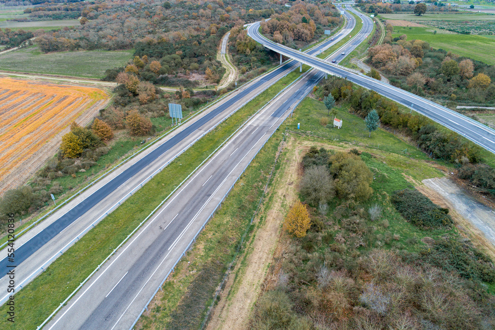 aerial drone view of a road crossing a highway over a highway overpass