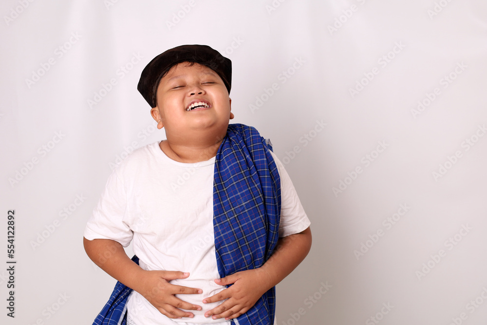 Asian boy feel very full after eating too much food. The boy holds his stomach full of food. Isolated on white background Asian boy feel very full after eating too much food. The boy holds his stomach full of food. Isolated on white background