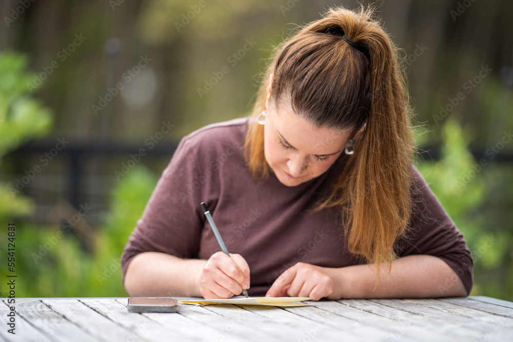 mature university student writing outside studying mature university student writing outside studying