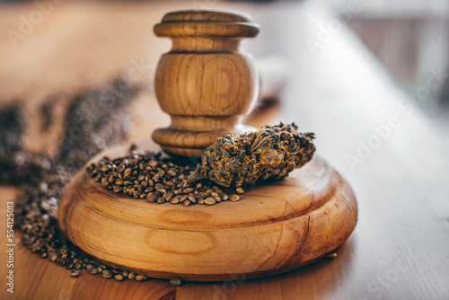 Legality of Medical Cannabis and Seeds, legal and illegal Cannabis, Seeds on the World - Wooden judge hammer and sound block with seeds and flower of marijuana CBD on the pinewood table background.