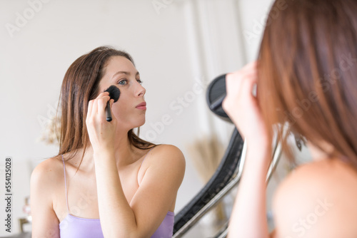 Girl applying makeup and mirror