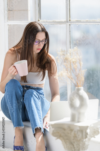 Girl working while seated at window