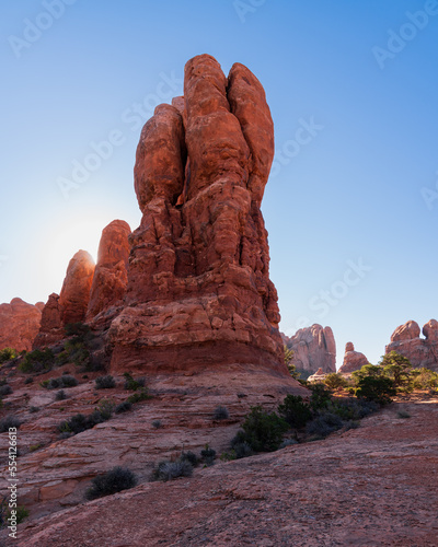 Morning sun behind rock formations - Arches National Park