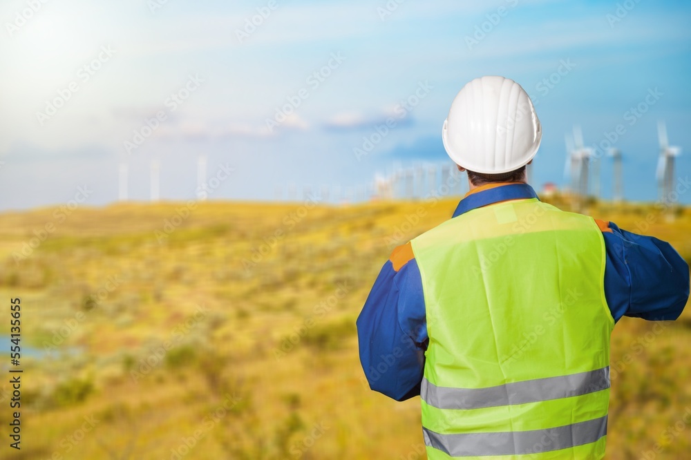 Young engineers working with wind turbine background Young engineers working with wind turbine background