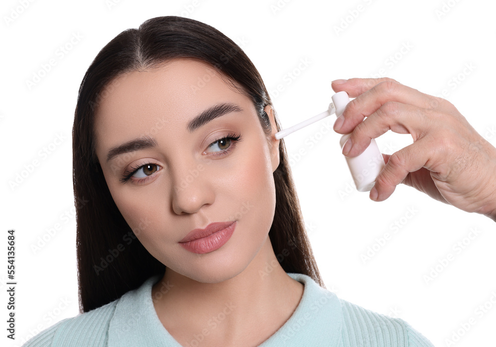 Doctor spraying medication into woman's ear on white background Doctor spraying medication into woman's ear on white background