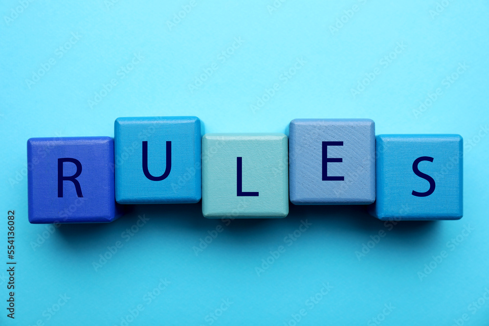 Word Rules made of wooden cubes with letters on light blue background, flat lay Word Rules made of wooden cubes with letters on light blue background, flat lay