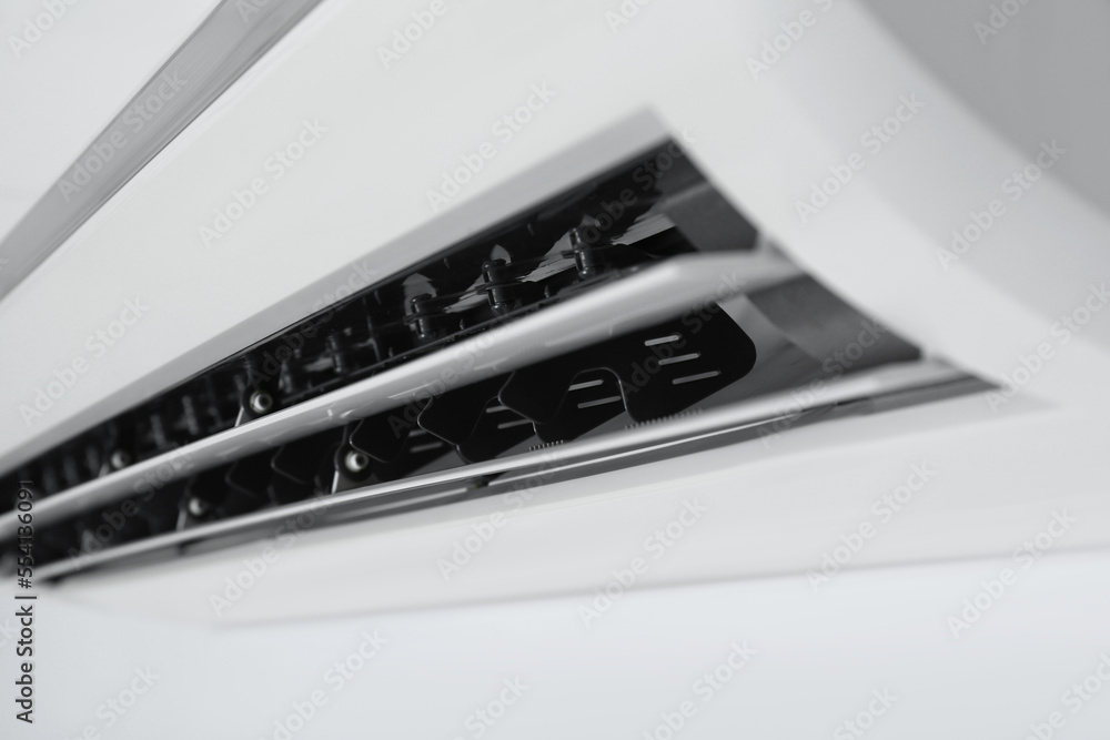 Modern air conditioner on white wall, closeup Modern air conditioner on white wall, closeup