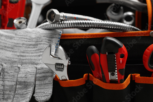 Plumber's bag with different tools, closeup view
