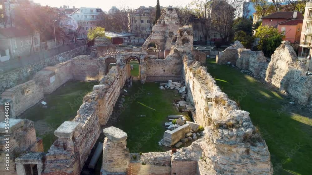 Drone flying over old ruins of Roman Thermae in Europe with green grass Drone flying over old ruins of Roman Thermae in Europe with green grass