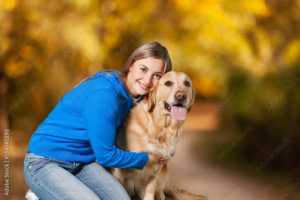 Happy young woman play with a dog on outdoors