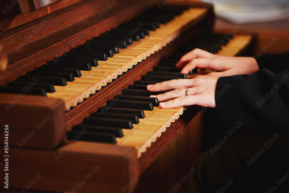 hands of a person playing the pipe organ